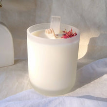 Load image into Gallery viewer, Kakadu Plum and Selenite candle with flowers in a glass container on a white surface
