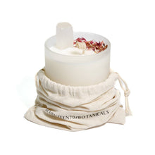 Load image into Gallery viewer, Kakadu Plum and Selenite Candle with dried flowers in a glass holder, wrapped in a branded cloth bag on a white background
