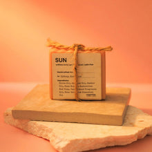 Load image into Gallery viewer, Small rectangular soap bar labeled 'SUN' on a wooden block with an orange background
