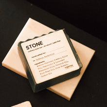 Load image into Gallery viewer, 'STONE' Bar of soap with a label on a black background
